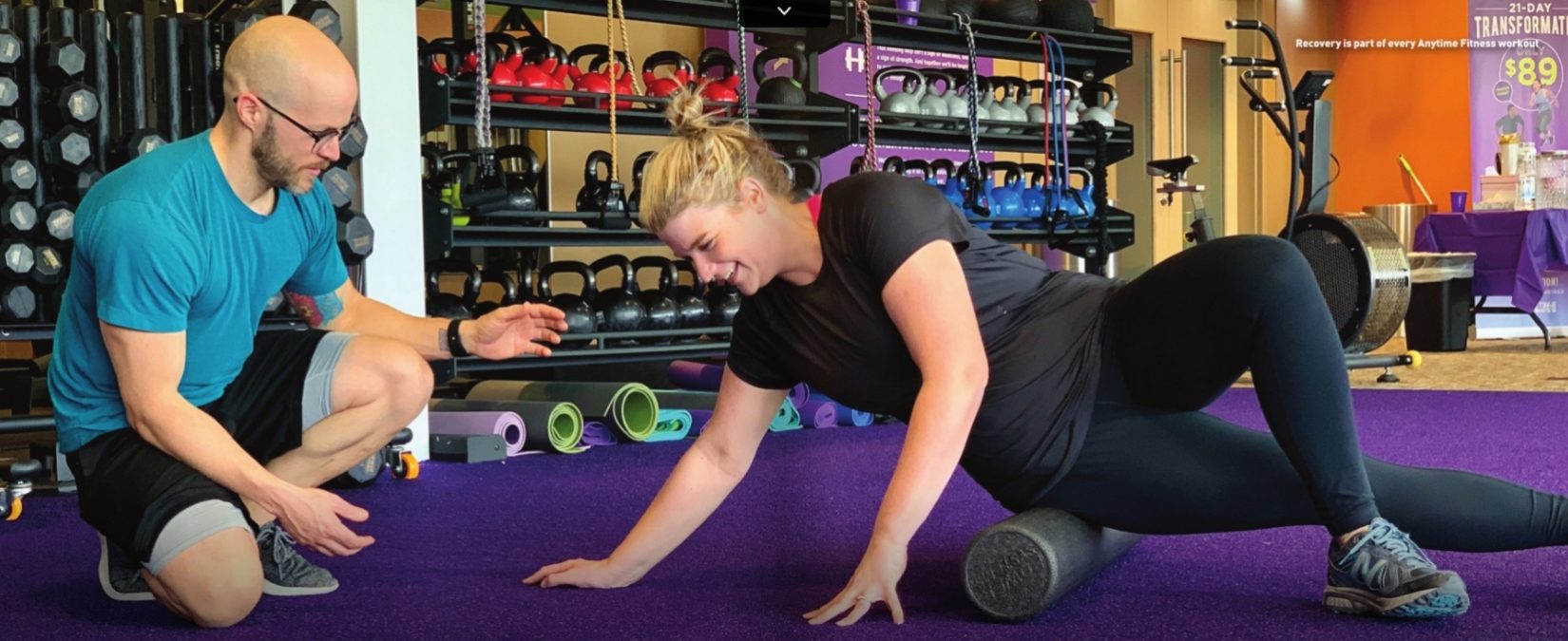 trainer helping a fitness club member with recovery